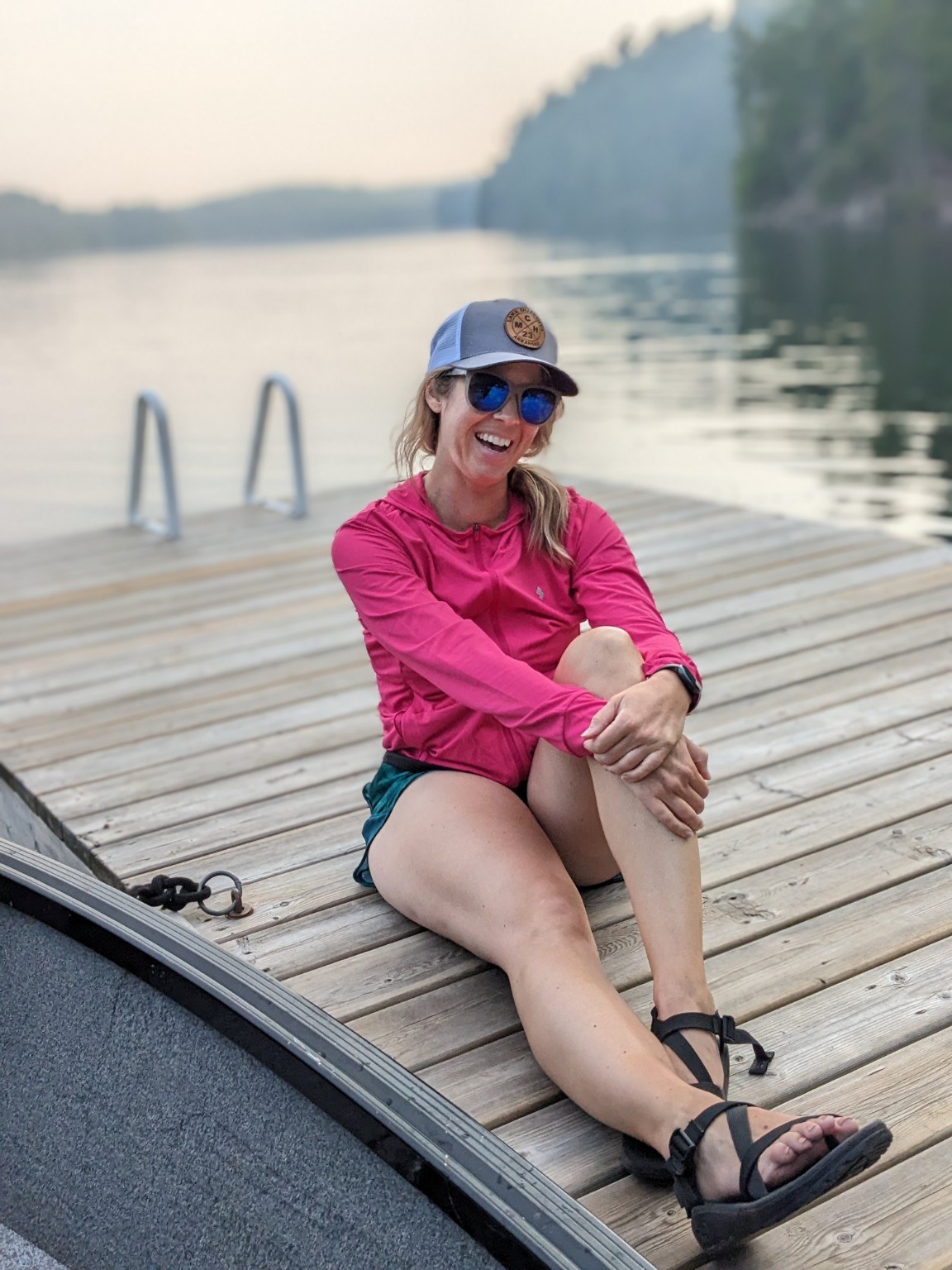 Katie Carstens sitting on a dock beside the water