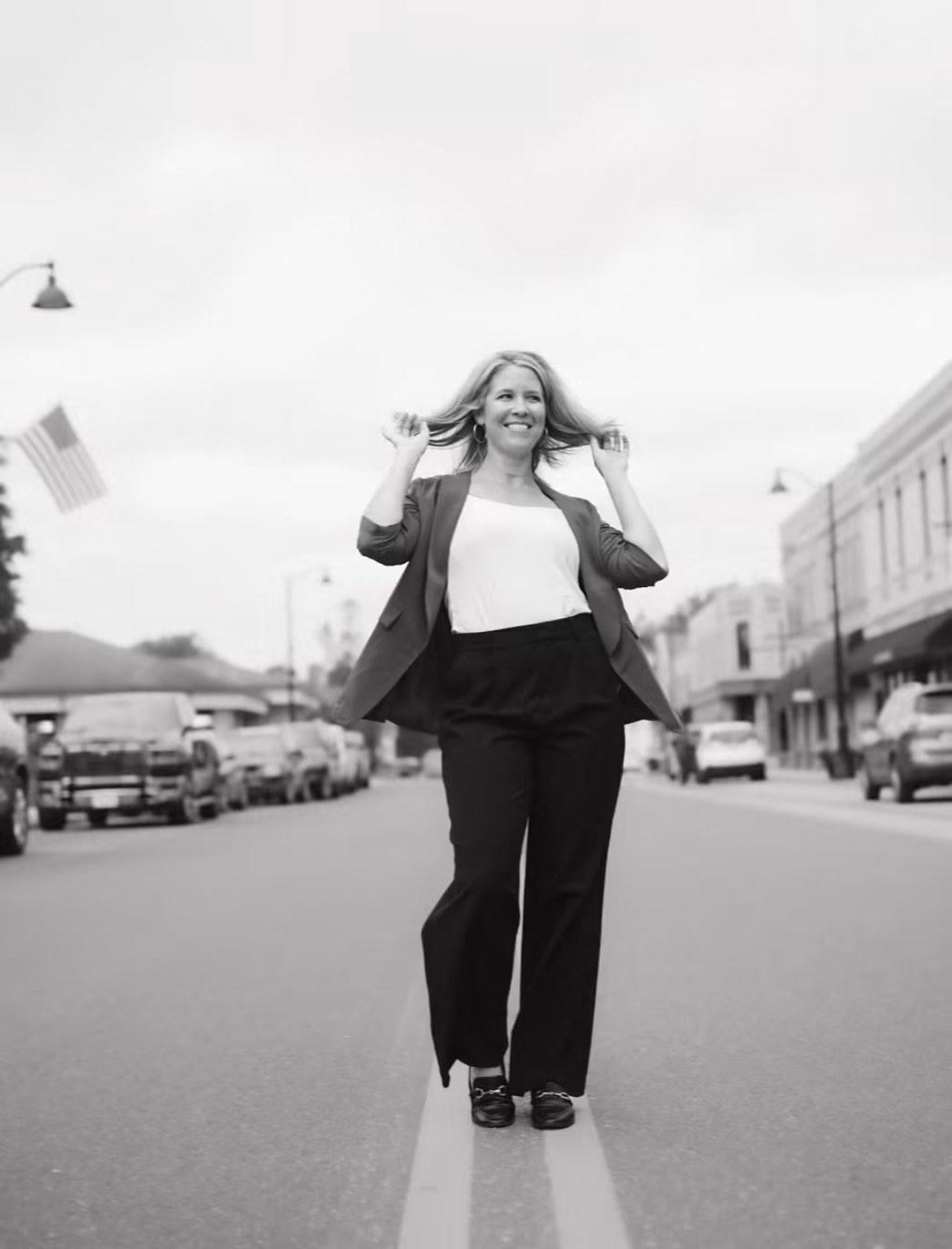 Katie Carstens walking outdoors in a black-and-white street portrait